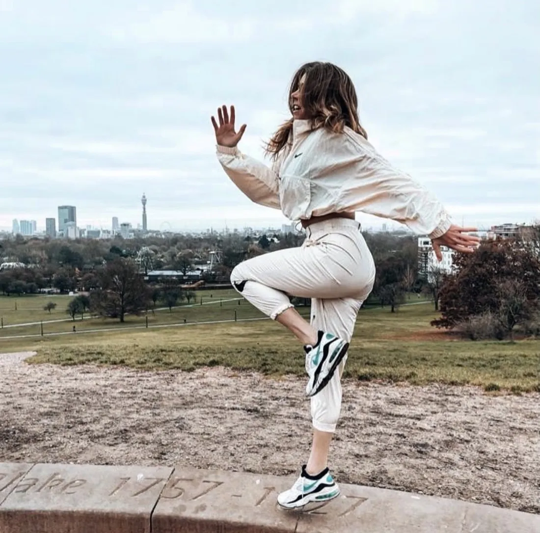 Louise Yerby training outdoors on Primrose Hill with the London skyline behind her